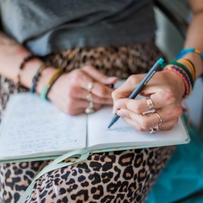 Lesley Logan - Author, Mindset Coach, and Fitness Guru writing in her notebook